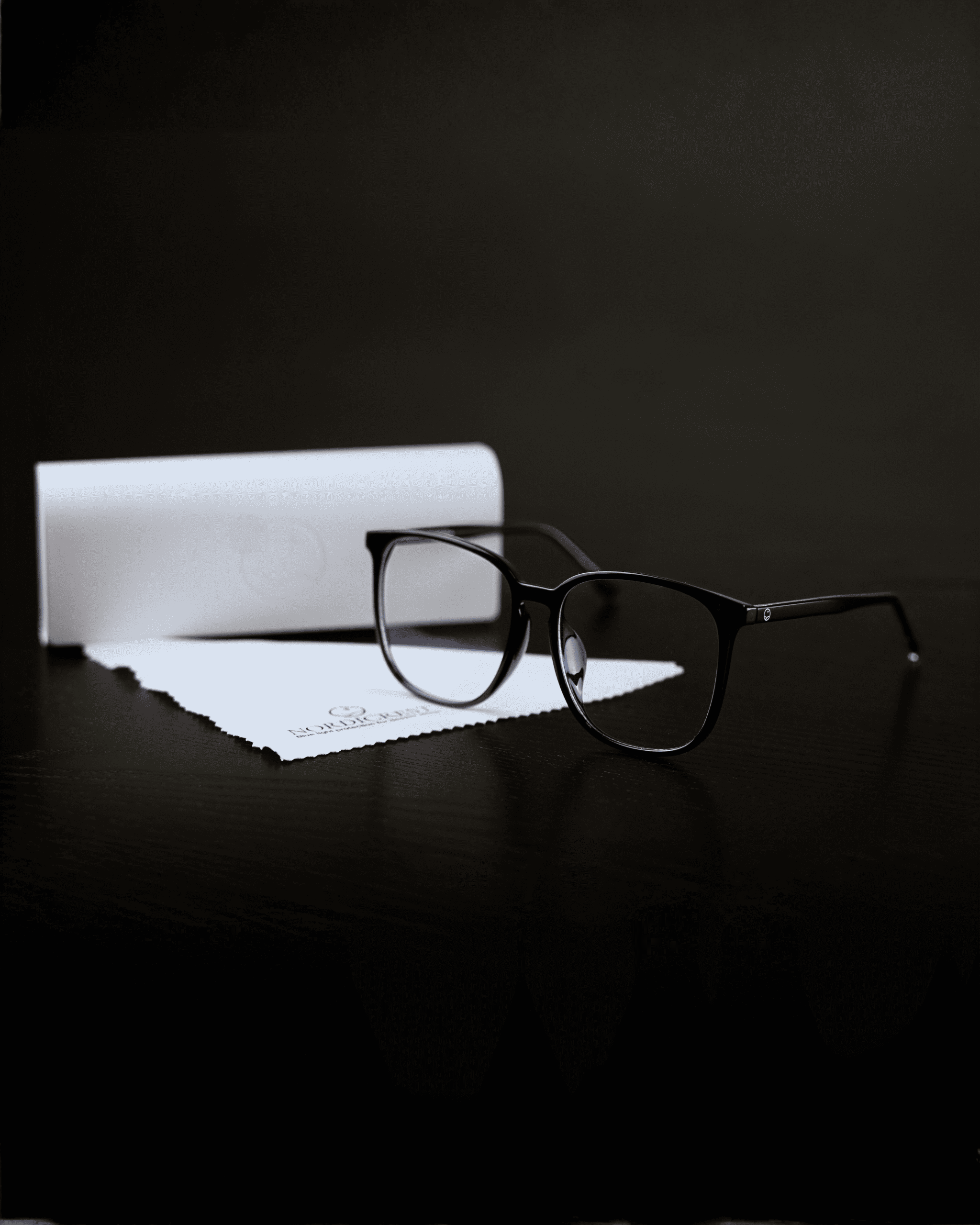 Arctic Black sinivalolasit ja pakkaus mustalla taustalla