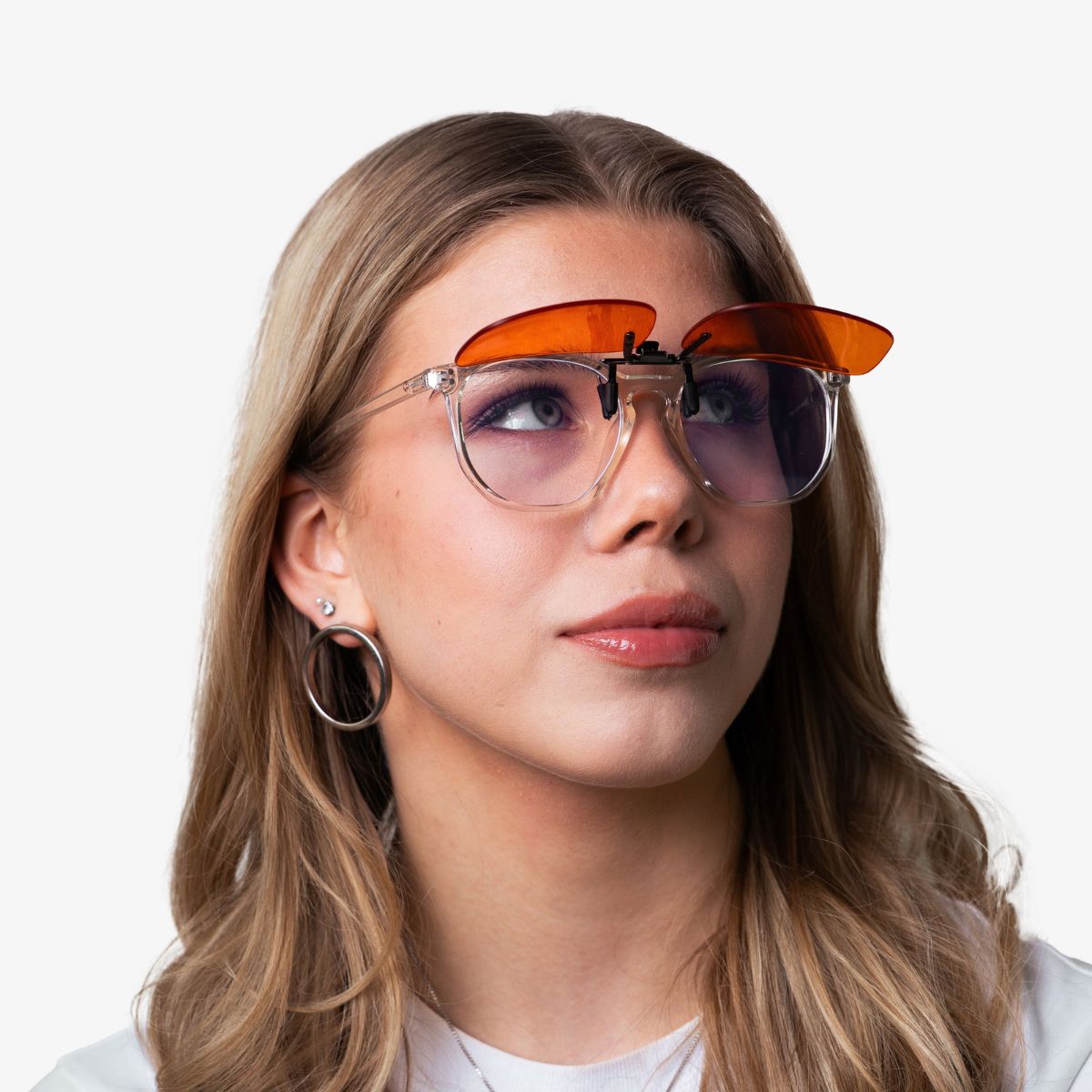 Nainen NordicRest Clip-On sinivalosuodattimella omien silmälasien päällä, oranssi linssi ylös käännettynä